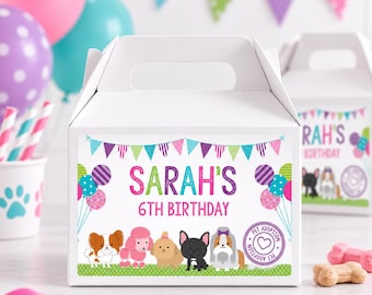 May include: A white cardboard gable box featuring a colorful label with the text "SARAH'S 6TH BIRTHDAY". The label displays a string of triangular pennants, balloons, and a row of five illustrated dogs, along with a circular "PET ADOPTION" stamp.
