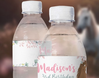 Op de afbeelding: Twee doorzichtige plastic waterflessen met gepersonaliseerde etiketten. De etiketten hebben een bloemmotief met roze en groene accenten. Eén etiket zegt "Madison's 3rd Birthday" met een bruine paardenillustratie.
