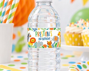 Op de afbeelding: Een doorzichtige plastic waterfles met een witte dop en een aangepast etiket met kleurrijke illustraties van oerwouddieren, groene bladeren en de tekst Preston's 2nd Birthday in blauwe en oranje letters op een witte achtergrond.