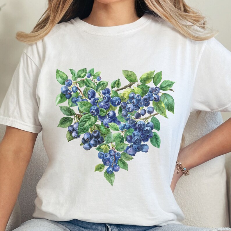 May include: White t-shirt with a watercolor illustration of blueberries in a heart shape.