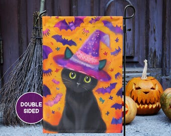 May include: Double-sided Halloween garden flag featuring a black cat wearing a purple witch hat. The flag has an orange background with purple bats and stars. The cat has green eyes and is centered on the flag.