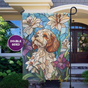 May include: Double-sided garden flag featuring a dog in a stained-glass style design. The flag showcases a dog with brown and cream fur, surrounded by white lilies and purple irises against a blue background. The flag is designed for outdoor use.
