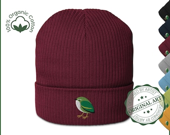 May include: A burgundy ribbed knit beanie with a small embroidered green and yellow bird on the front. The hat is made of 100% organic cotton. A green and white seal reads "Designed by Artist Original Art".