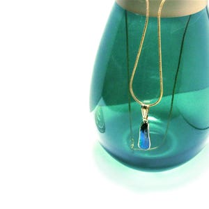 Halsketting met blauwe parelmoeren hanger: Verguld kettinkje met hanger van abalone schelp.