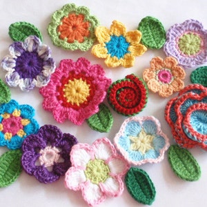 May include: A collection of crocheted flowers in various colours, including pink, blue, yellow, green, and red. The flowers are all different sizes and shapes, and some have leaves attached.