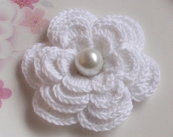 May include: A white crocheted flower with a pearl in the center.