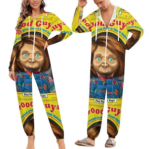 Puede incluir: Mono amarillo con un diseño de muñeco Chucky. El mono tiene capucha, cremallera y el texto "Good Guy" y "Play Pals Toys". El muñeco Chucky tiene ojos azules y pelo rojo.