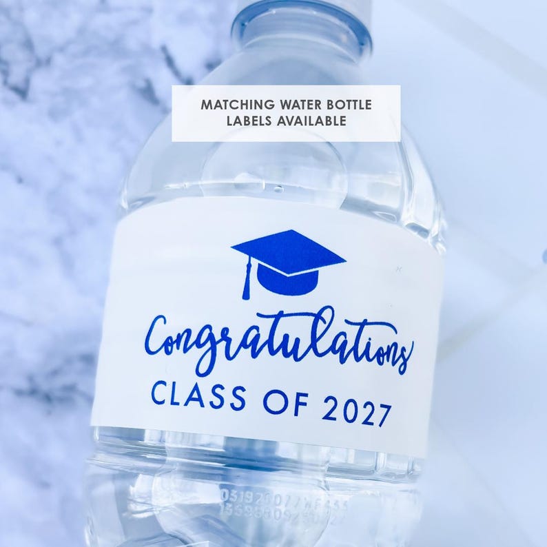 May include: Clear plastic water bottle with a white label. The label features a blue graduation cap graphic and the words "Congratulations CLASS OF 2027" in blue script. Text at the top reads "MATCHING WATER BOTTLE LABELS AVAILABLE".