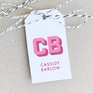 May include: White gift tag with pink 3D letters "CB" and the text "CASSIDY BARLOW" below.