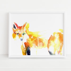 Puede incluir: Pintura a la acuarela de un zorro en tonos naranja, amarillo y negro, enmarcada en blanco. El zorro tiene ojos verdes y está representado en un estilo semirrealista. La obra de arte se exhibe sobre un fondo blanco.