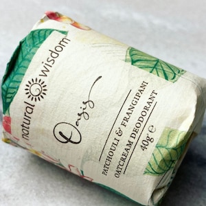 May include: A white tube with green and floral designs. The tube is labeled "natural wisdom" and "Patchouli & Frangipani Oatcream Deodorant 40g e".