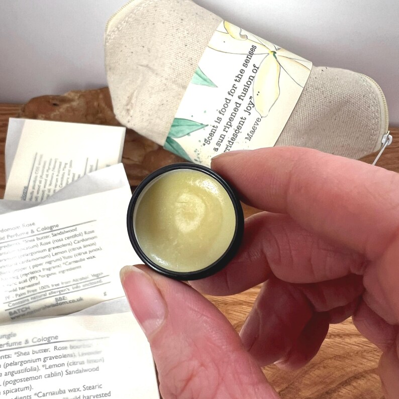 Pu&ograve; includere: Un piccolo contenitore rotondo nero con un coperchio, riempito di un balsamo giallo chiaro. Il balsamo &egrave; liscio e cremoso, e il contenitore &egrave; etichettato con il testo "*Scent is food for the senses a sun ripened fusion of iridescent joy...* Maeve".