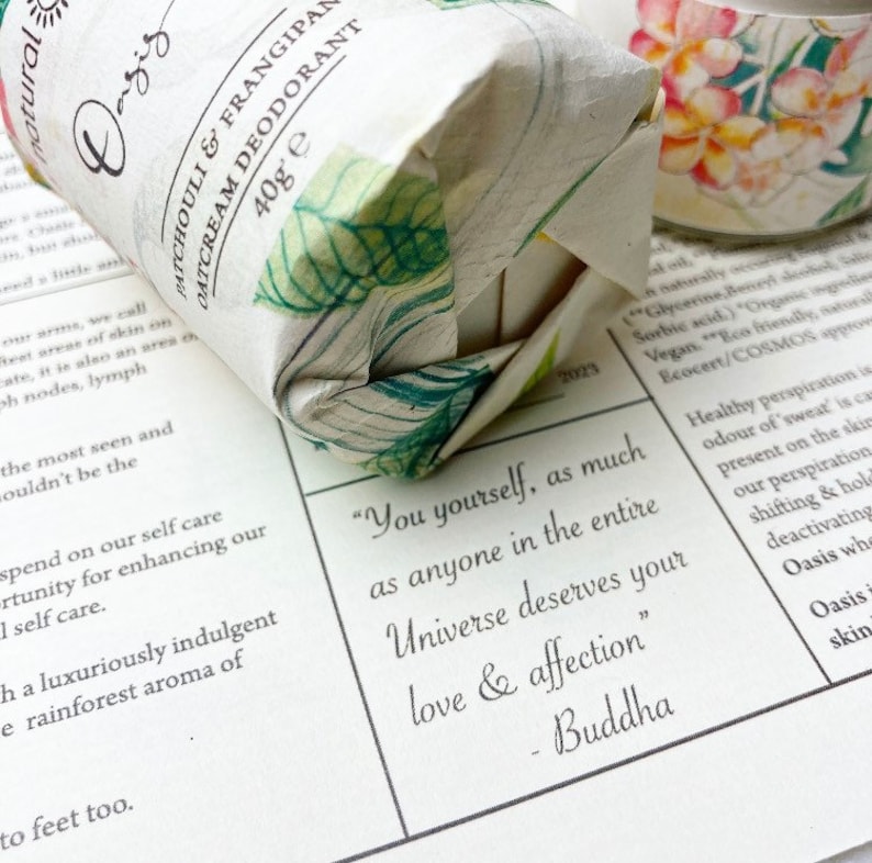 May include: A white and green wrapped bar of natural deodorant with the text "Patchouli & Frangipani Oatcream Deodorant 40g e" printed on the wrapper. The quote "You yourself, as much as anyone in the entire Universe deserves your love & affection" - Buddha is printed on a white background.
