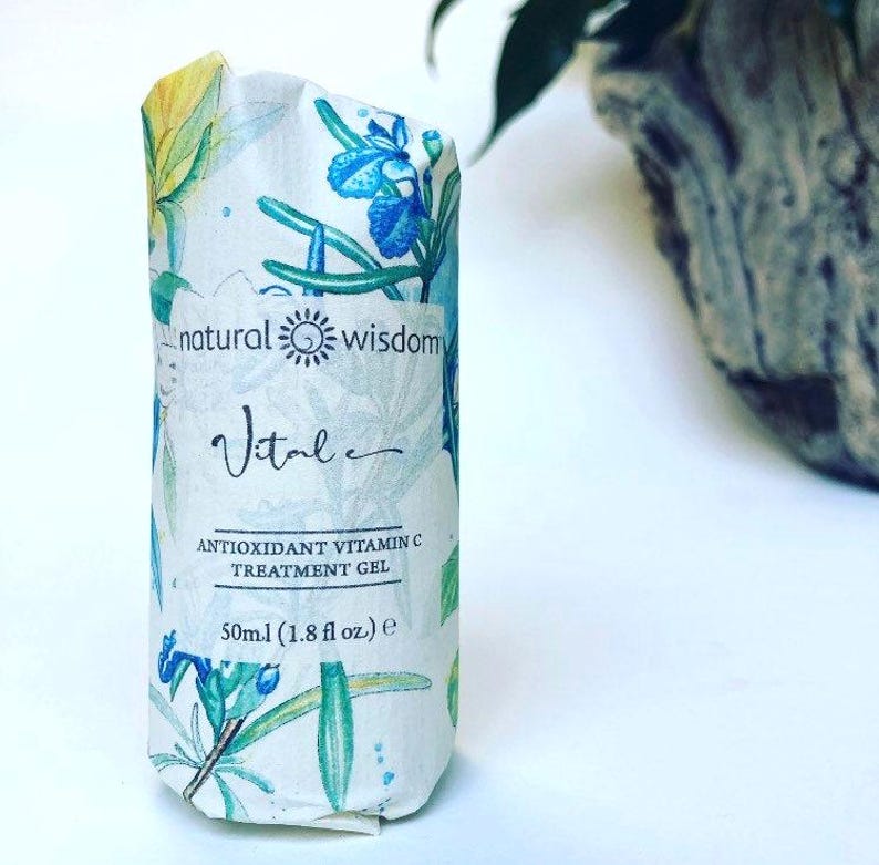 May include: A white bottle with a floral design and the text "natural wisdom Vital ANTIOXIDANT VITAMIN C TREATMENT GEL 50ml (1.8 fl oz.) e" printed on it.