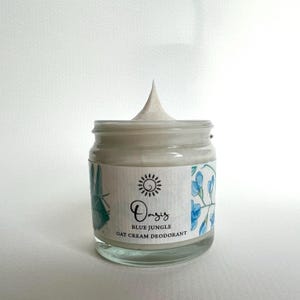 May include: A white jar of Oasis Blue Jungle Oat Cream Deodorant with a blue and green floral design on the label.
