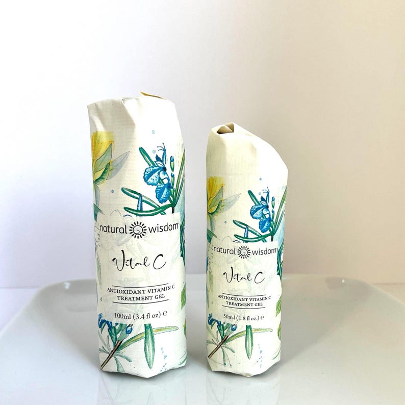 May include: Two bottles of natural wisdom Vital C Antioxidant Vitamin C Treatment Gel. The smaller bottle is 50ml (1.8 fl oz) and the larger bottle is 100ml (3.4 fl oz). Both bottles have a white background with a floral design and the text "natural wisdom" and "Vital C" in blue and yellow.