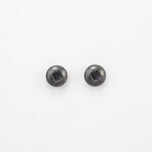 Könnte beinhalten: Ein Paar silberne Ohrstecker mit einem quadratischen Design in der Mitte.