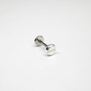 Puede incluir: Pendiente de tornillo de plata con parte posterior plana.