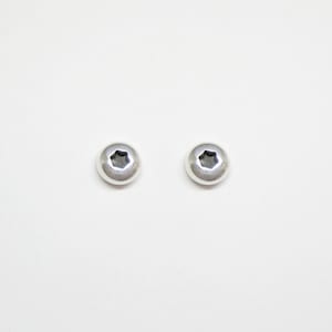May include: A pair of silver stud earrings with a slightly domed shape and a star-shaped cutout in the center.