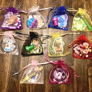 May include: Twelve small organza bags filled with various small toys and trinkets. The bags are tied with ribbons and are arranged in a row on a wooden surface.