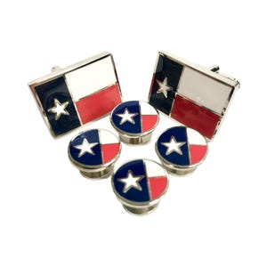 May include: A set of cufflinks and shirt studs featuring the Texas state flag. The cufflinks and studs are silver-toned with blue, white, and red enamel.