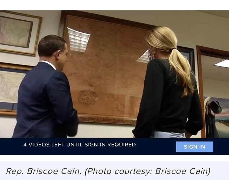 May include: A man and a woman are looking at a framed map. The map is brown and has a white seal in the lower right corner. The man is wearing a dark suit and the woman is wearing a black shirt and jeans. The text on the image reads "4 VIDEOS LEFT UNTIL SIGN-IN REQUIRED" and "SIGN IN". The text below the image reads "Rep. Briscoe Cain. (Photo courtesy: Briscoe Cain)".