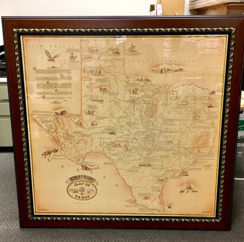 May include: A framed map of Texas with a vintage aesthetic. The map is printed on a cream-colored background with brown lines and text. The map is surrounded by a brown frame with a gold-colored trim.