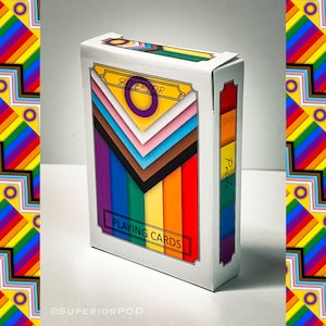 May include: A white box of playing cards with a Pride theme. The box features a colorful design with the word "SUPERIOR" and the text "PLAYING CARDS". The side of the box reads "Pride". The design incorporates various Pride flag colors.