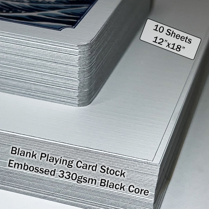 May include: A stack of 10 blank playing card stock sheets, each measuring 12" x 18". The sheets are embossed and have a black core. The text "Blank Playing Card Stock Embossed 330gsm Black Core" is printed on the side of the stack.