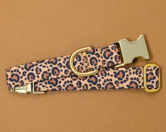 May include: A brown and black leopard print dog collar with a gold metal buckle and a silver metal clasp.