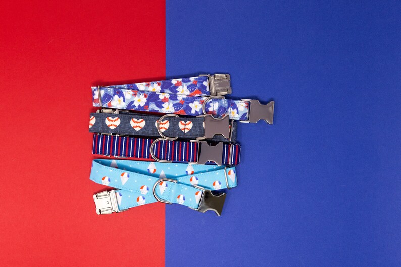 Puede incluir: Una pila de cinco collares de perro coloridos con diferentes patrones, que incluyen flores, b&eacute;isbol, rayas y conos de helado. Los collares son todos azules y blancos con hebillas plateadas.