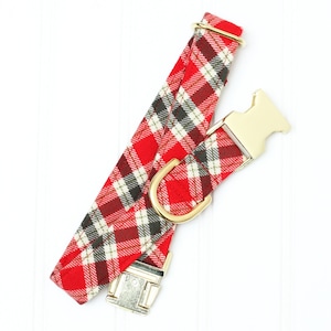 Op de afbeelding: Hondenhalsband van rood en zwart geruit stof met gouden gespen.