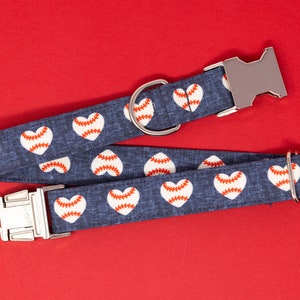 Könnte beinhalten: Ein blaues Hundehalsband mit einem weißen Baseball-Herz-Muster und silberner Hardware.