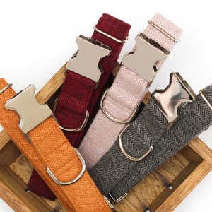 Puede incluir: Cuatro collares para perros en una caja de madera. Los collares est&aacute;n hechos de tela de espiga y tienen hebillas plateadas. Los colores de los collares son naranja, burdeos, gris y rosa.