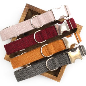 Puede incluir: Cuatro collares para perros en diferentes colores: rosa, rojo, naranja y gris. Los collares est&aacute;n hechos de una tela con estampado de espiga y tienen hebillas de metal plateado.