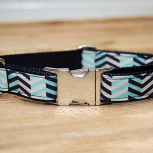 May include: A blue and white chevron patterned dog collar with a silver buckle.