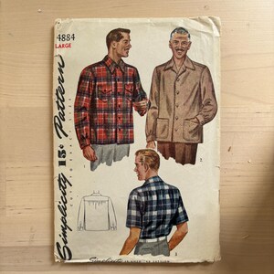 May include: Vintage Simplicity 15¢ pattern for men's shirts. The pattern features illustrations of three shirt styles: a red and black plaid long-sleeve shirt, a tan button-up jacket, and a blue and white plaid short-sleeve shirt. The pattern is labeled "4884 LARGE".