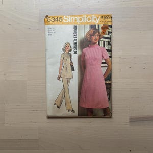 May include: Vintage Simplicity Designer Fashion sewing pattern, size 16. The cover features illustrations of a woman in a pink dress and a woman in a beige pantsuit. The pattern includes bust 38" and waist 30" measurements.