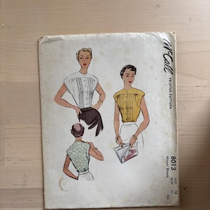 May include: Vintage McCall's sewing pattern for a Misses' Blouse, size 16. The pattern features illustrations of the blouse in different colors and styles. The cover is off-white with the McCall's logo and pattern details printed on it.