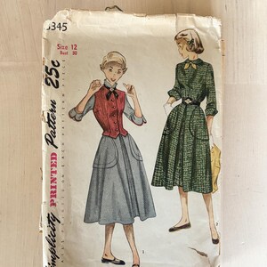 May include: A vintage Simplicity sewing pattern envelope, number 345, size 12, bust 30. The front features illustrations of two outfits: a grey skirt with a red vest, and a green plaid dress with a belt. The text reads Simplicity Printed Pattern 25c.