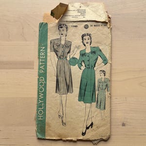 May include: Vintage Hollywood Pattern envelope with illustrations of women's dresses. The envelope is aged with a green spine that reads "Hollywood Pattern." The pattern number is 1380, with bust and hip measurements.
