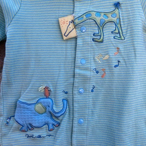 Puede incluir: Un pelele de beb&eacute; a rayas azules y verdes con un dise&ntilde;o bordado de elefante y jirafa. El pelele tiene un cuello azul y se abrocha con botones en la parte delantera.