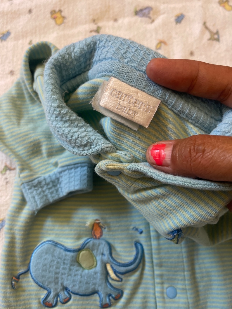 Puede incluir: Mono de beb&eacute; a rayas azules y amarillas con un elefante bordado y el texto "Carter's Baby" en la etiqueta.