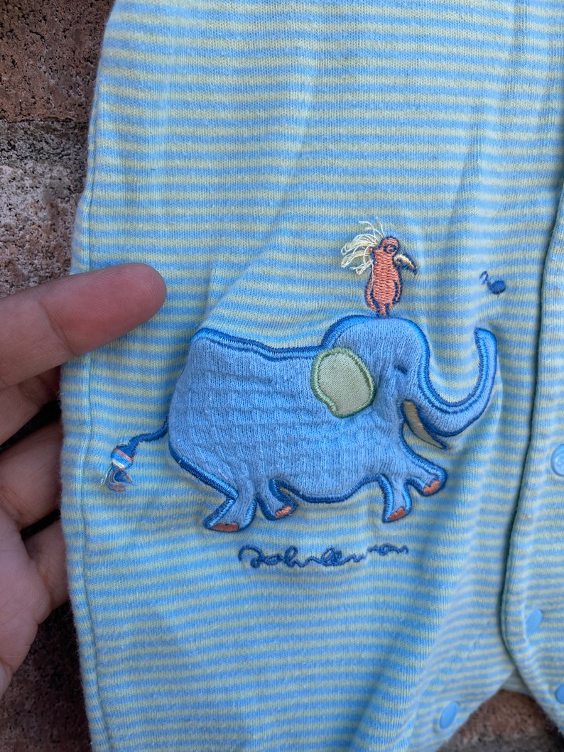 Puede incluir: Mono de beb&eacute; a rayas azules y amarillas con un dise&ntilde;o bordado de elefante y p&aacute;jaro. El mono tiene el texto "Baby" bordado en la parte inferior.