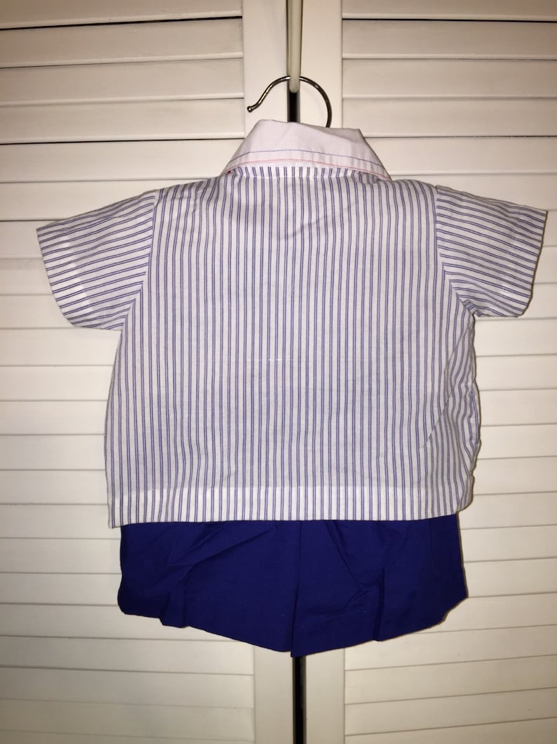May include: A white and blue striped short-sleeved shirt with a white collar and a blue pair of shorts.