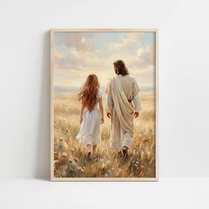 Op de afbeelding: Een ingelijste kunstdruk toont twee figuren die door een veld met hoog gras en wilde bloemen lopen. Eén figuur heeft lang rood haar en draagt een witte jurk. De andere figuur draagt een wit gewaad. De achtergrond toont een bewolkte lucht.