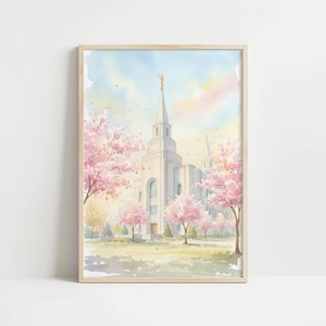 Può includere: Dipinto ad acquerello di un tempio bianco con un'alta guglia, sormontata da una statua dorata. Alberi in fiore rosa incorniciano l'edificio, sullo sfondo di un cielo pastello. L'opera è esposta in una cornice di legno chiaro.