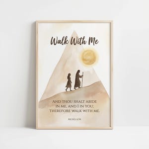Pode incluir: Impressão de arte emoldurada com uma ilustração em aquarela. A obra apresenta duas figuras caminhando por uma colina em direção a um sol, com o texto "Walk With Me" no topo. A parte inferior da impressão inclui um versículo bíblico de Moisés 6:34.