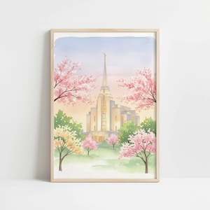 May include: Watercolor print of a temple with a tall spire, surrounded by pink cherry blossom trees and lush green foliage. The artwork is framed in a light wood frame, set against a soft, pastel sky.