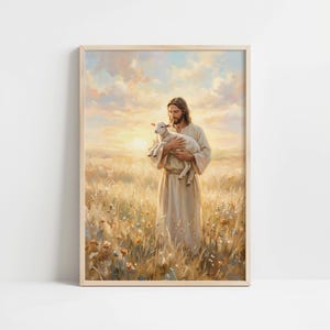 May include: A framed print depicts a figure in a cream-colored robe holding a lamb in a field of tall grass and wildflowers. The background features a sunset with soft, warm colors. The artwork is in a wooden frame.